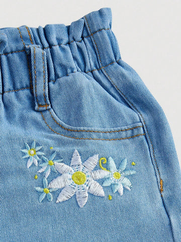 Young Girl Stylish Water-Washed Jeans With Paperbag Waist And Embroidered Flowers Young Girl Stylish Water-Washed Jeans With Paperbag Waist And Embroidered Flowers
